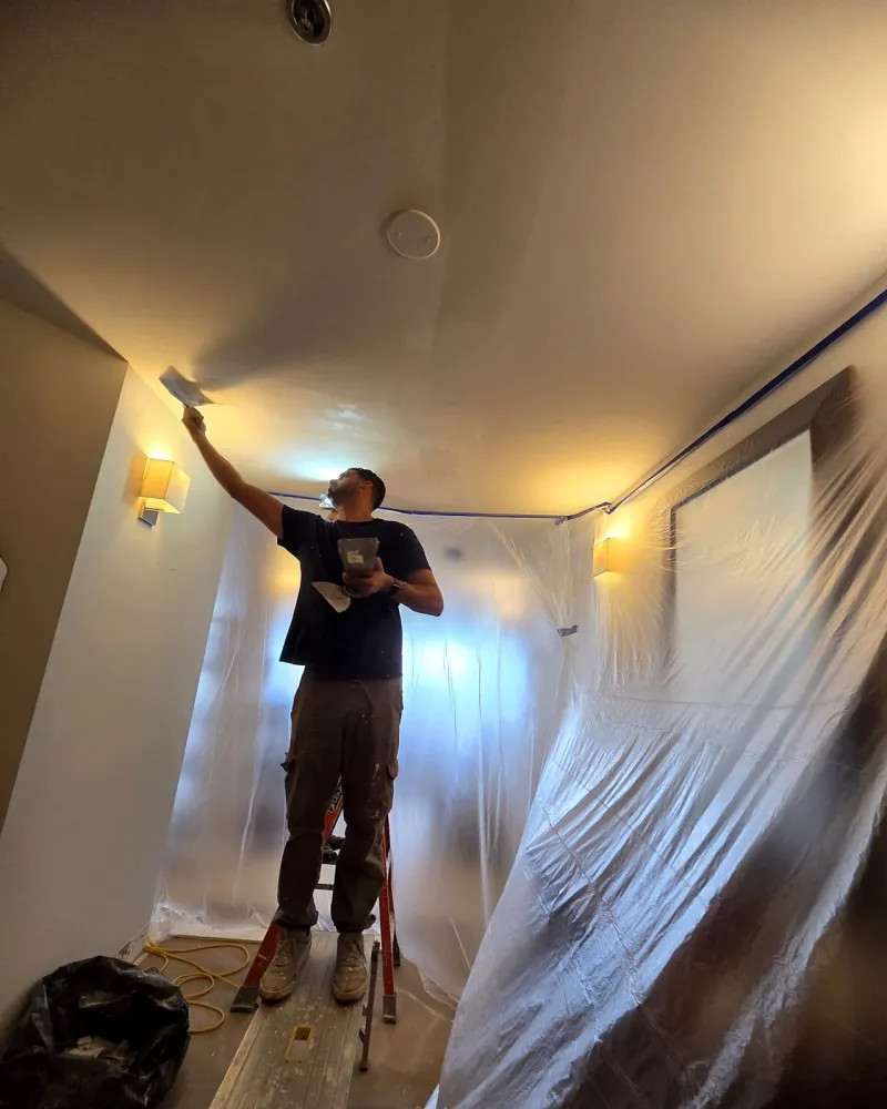 Crew applying skim coat plaster to a ceiling, Miami